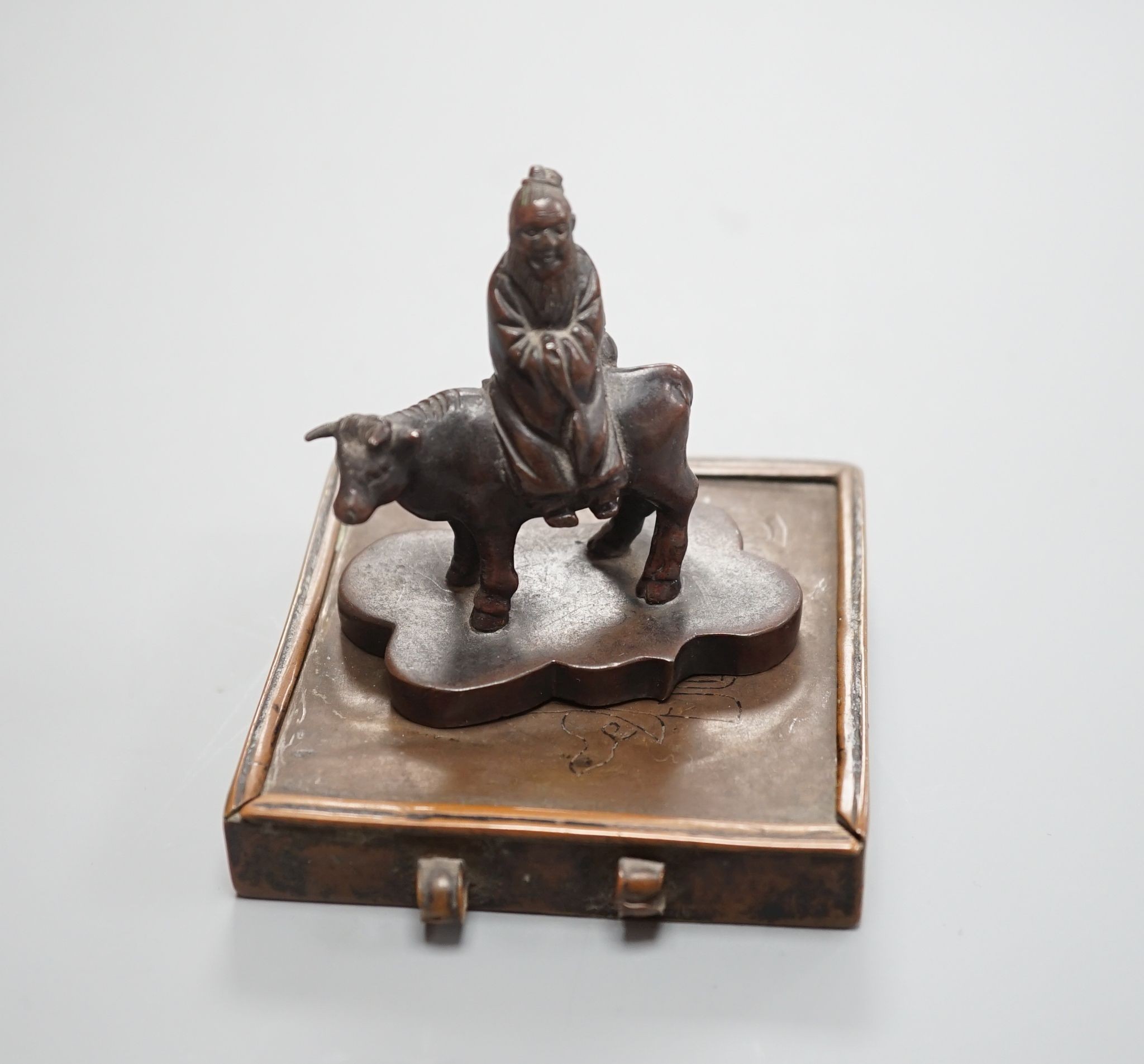 A small Chinese bronze seal of an immortal riding a bull and a Tibetan prayer case 9cm